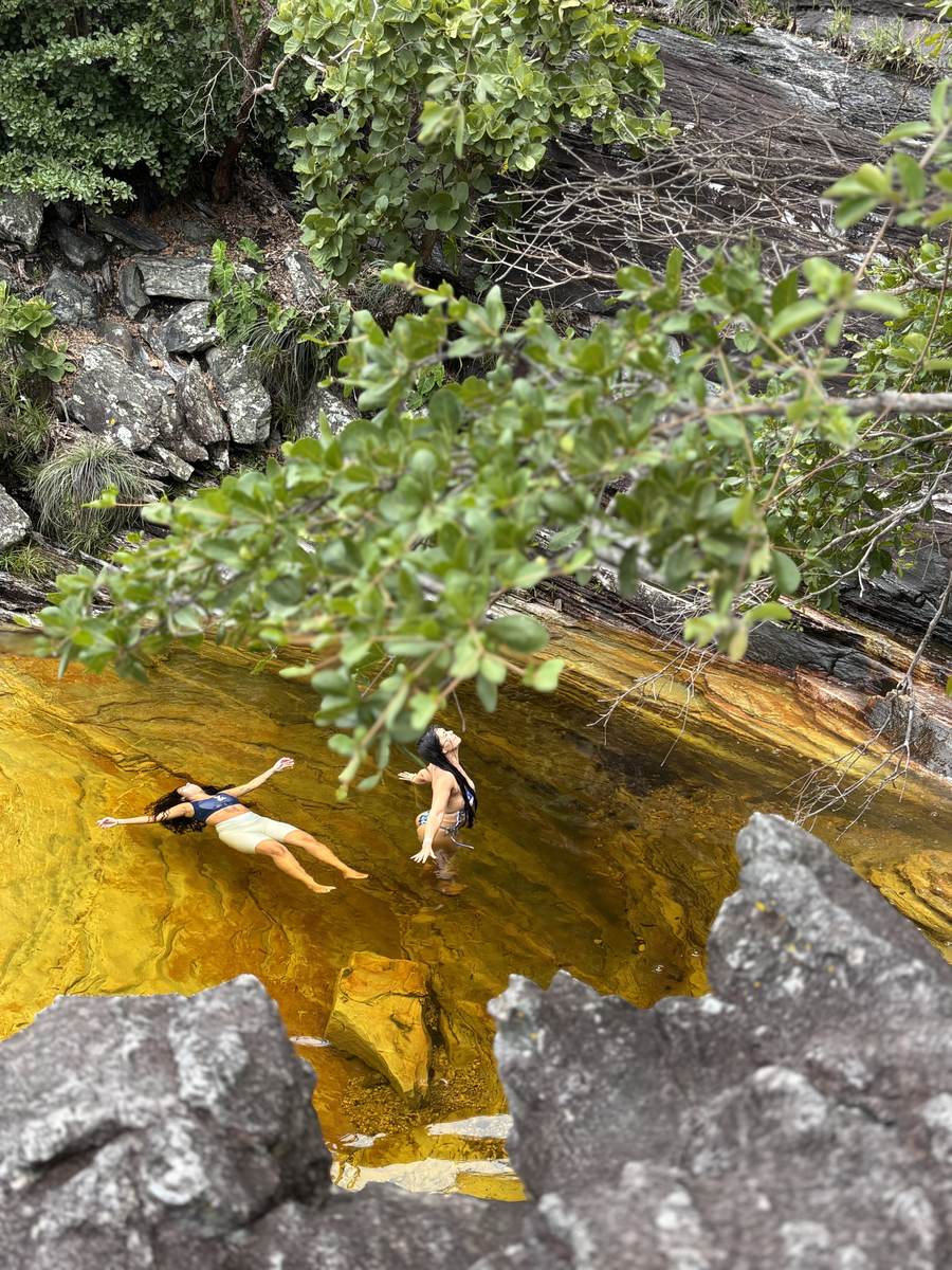 Two women resting in a clear river pool in the Cerrado