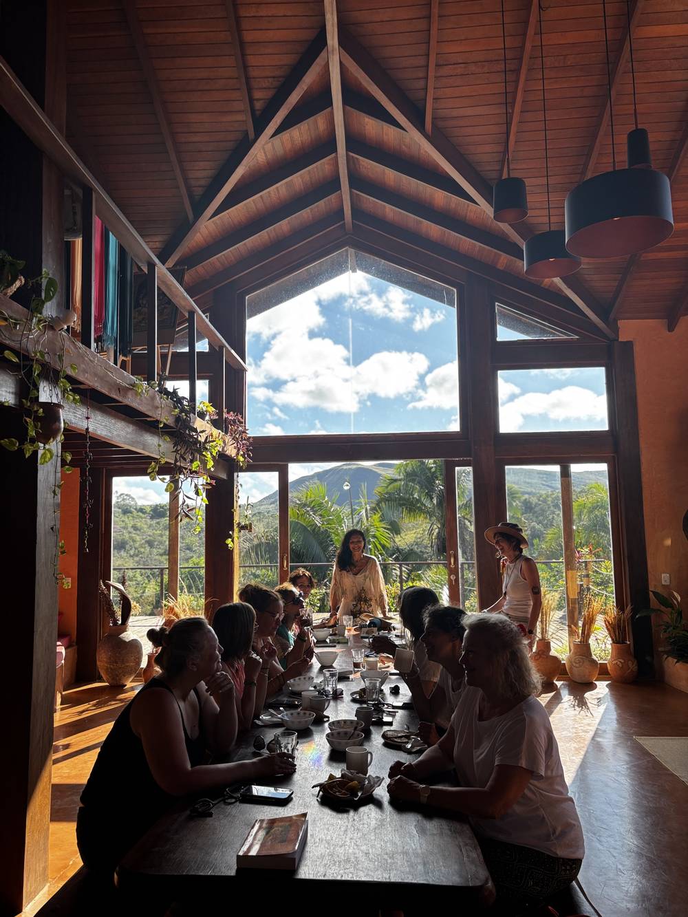 A retreat group sharing a meal at the long communal table